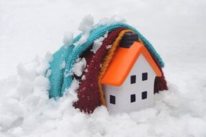 HOUSE COVERED BY BLANKETS IN SNOW RE COLD WEATHER PAYMENT HOME INSULATION RISING FUEL COSTS HEATING ICE STAYING WARM GAS BILL UK. Image shot 2016. Exact date unknown.