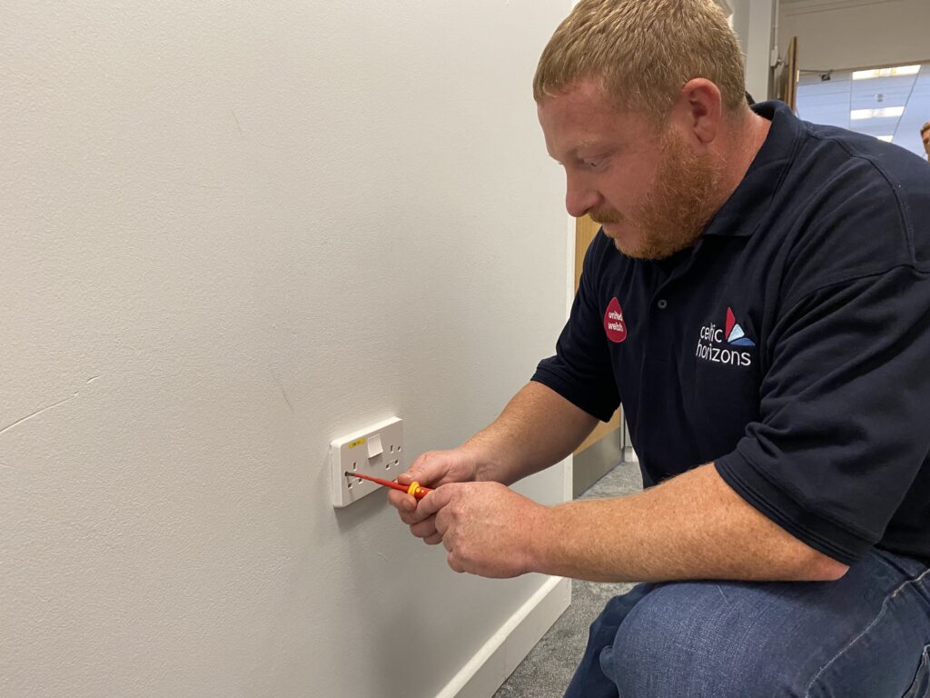 An image of a Celtic Horizons operative working on a plug socket