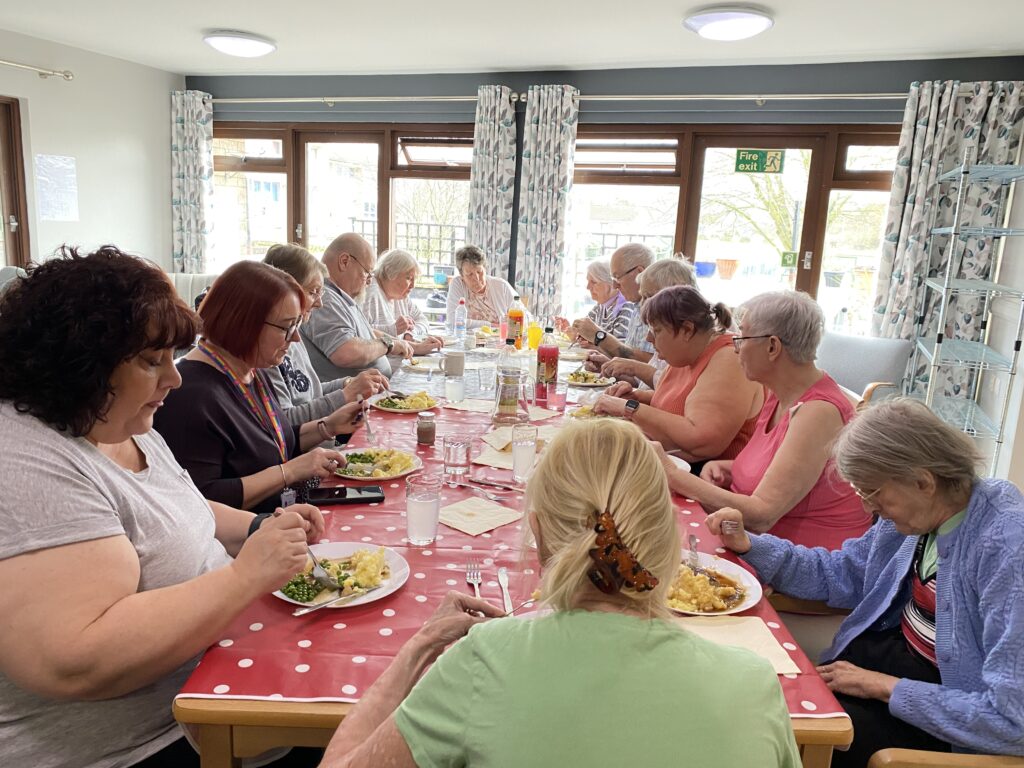 A group of people sitting at the table eating lunch.