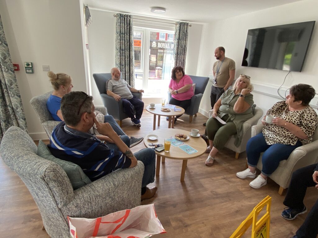 An image of people sat around chatting in a communal area