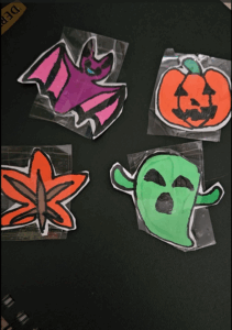Homemade stickers. L:R a purple bat, a jack-o-lantern, an autumn leaf, and a green ghost.