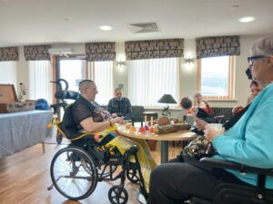 Residents at Llys Nant Y Mynydd at Life Music event with percussive instruments on the table.