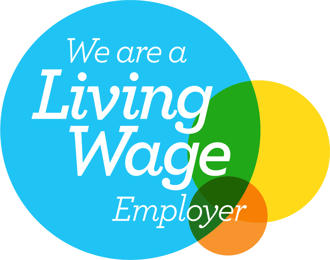 An image of the Real Living Wage logo. It shows a blue yellow and orange circle and says we are a living wage employer in white text.