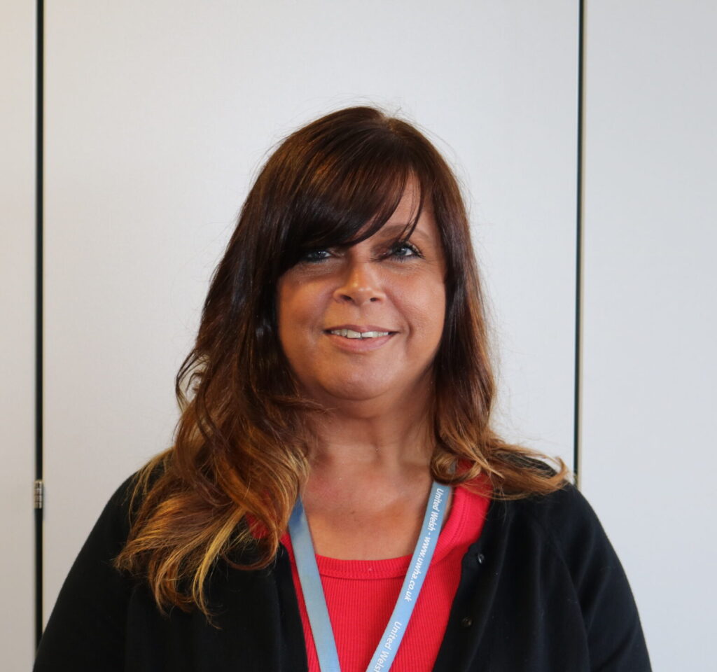 A photo of a woman with medium length brown hair wearing a black top