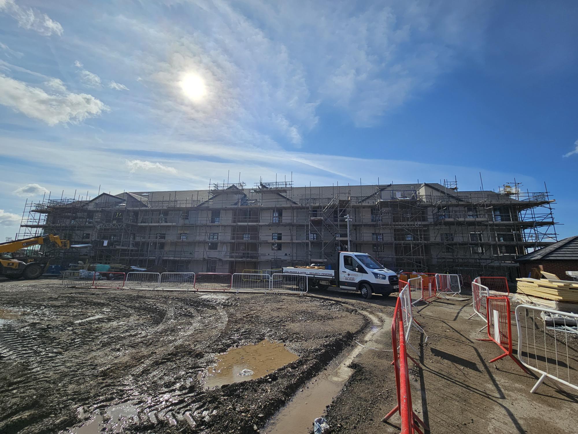 An image of an apartment building in development at Barry Waterfront. There is scaffolding in front of the four-story building and a truck.