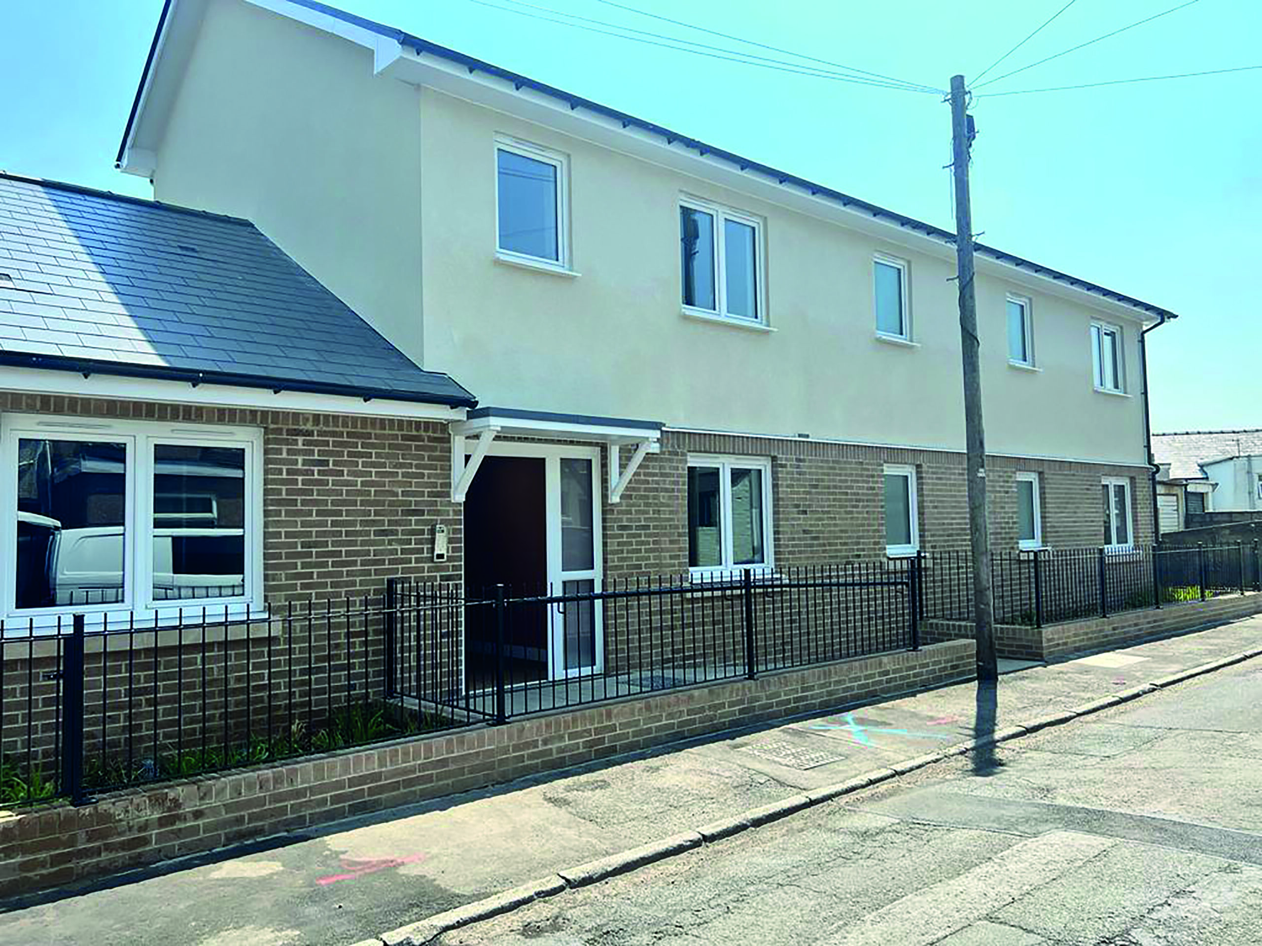 An external image of Acer House, a United Welsh development in Brynmawr. The top floor of the building is a cream render, and the bottom half is a light brown brick.